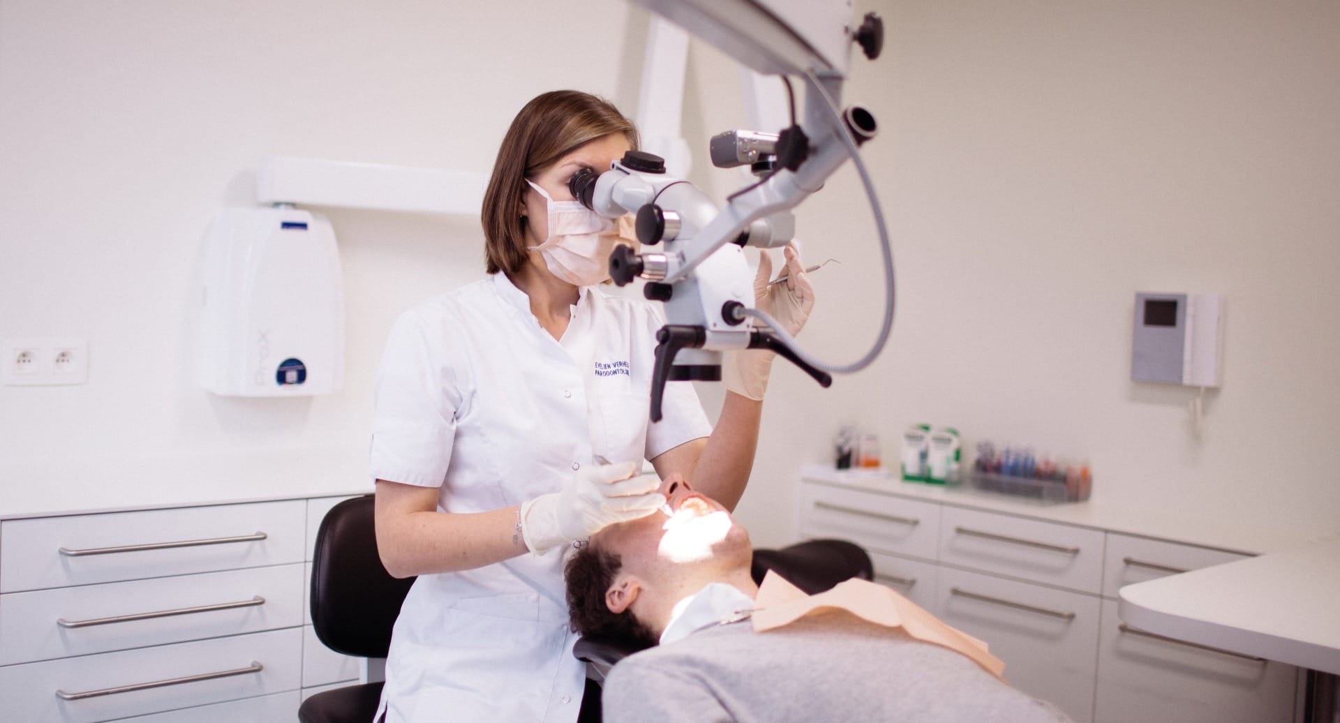Endodontoloog aan het werk met operatiemicroscoop bij Dentall Waregem