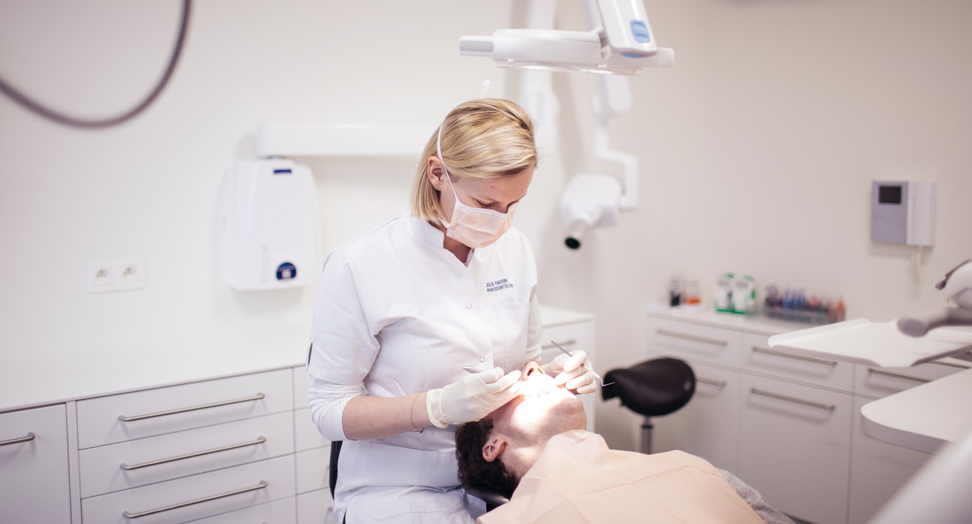 Specialist parodontologie behandelt een patient in de moderne behandelkamer van Dentall Waregem